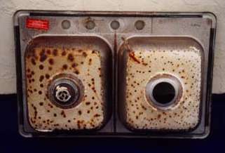 Bottom of corroded sink showing the extent of corrosion damage